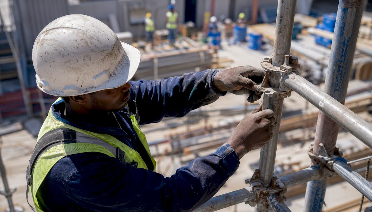Subcontractor assembling scaffolding on site