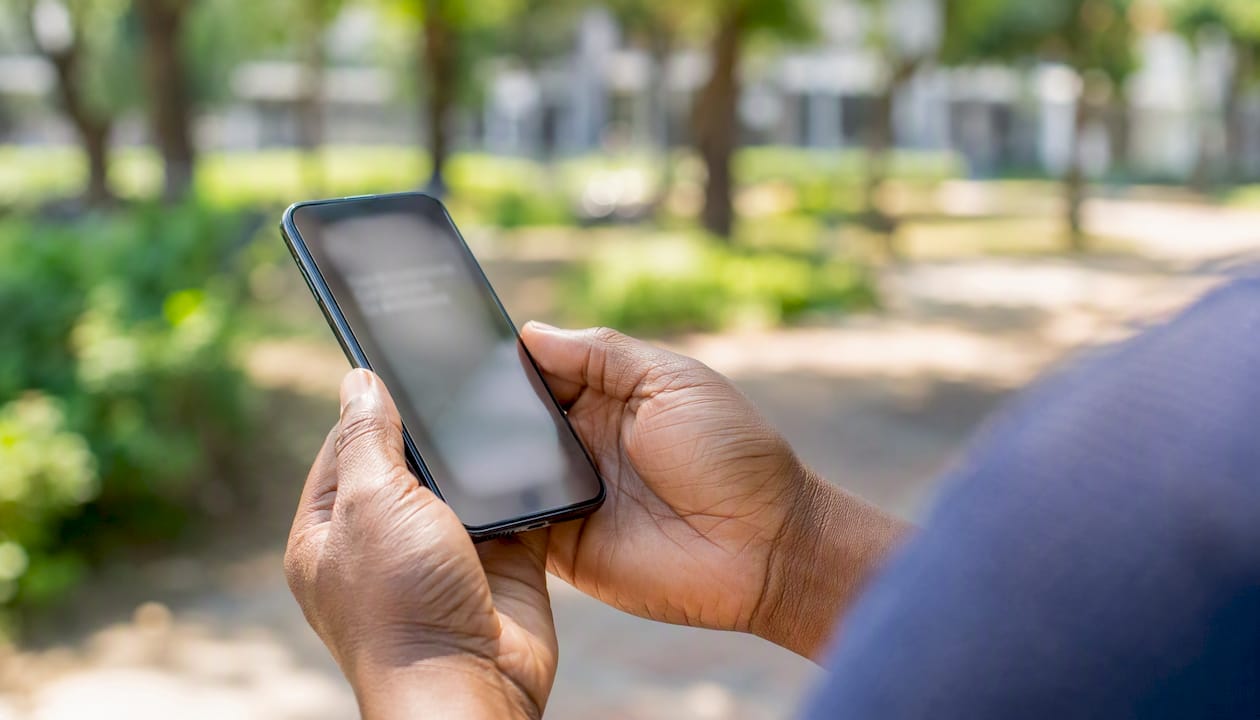 Hands holding phone with blurred scam alert