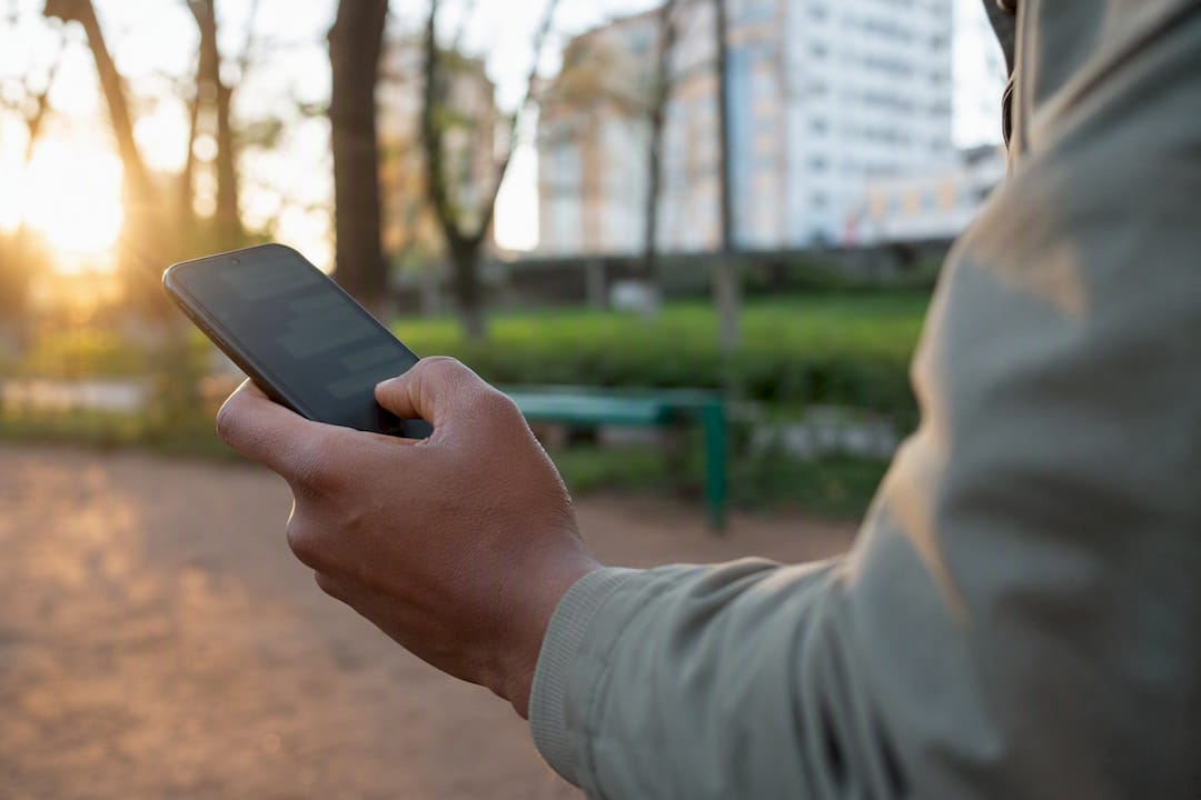 Hand holding phone with blurred WhatsApp chat