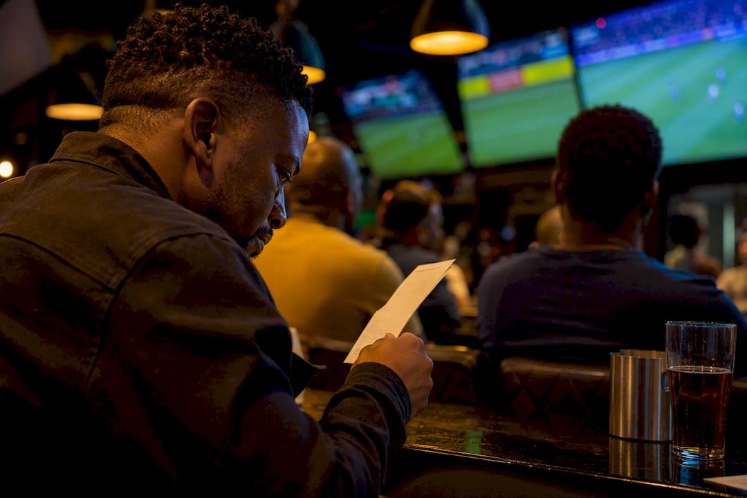 Hand holding betting slip in sports bar