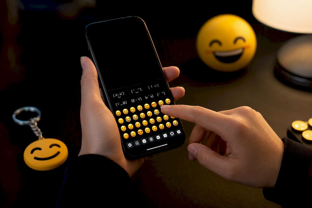 Hands holding smartphone ready to customize kaomoji