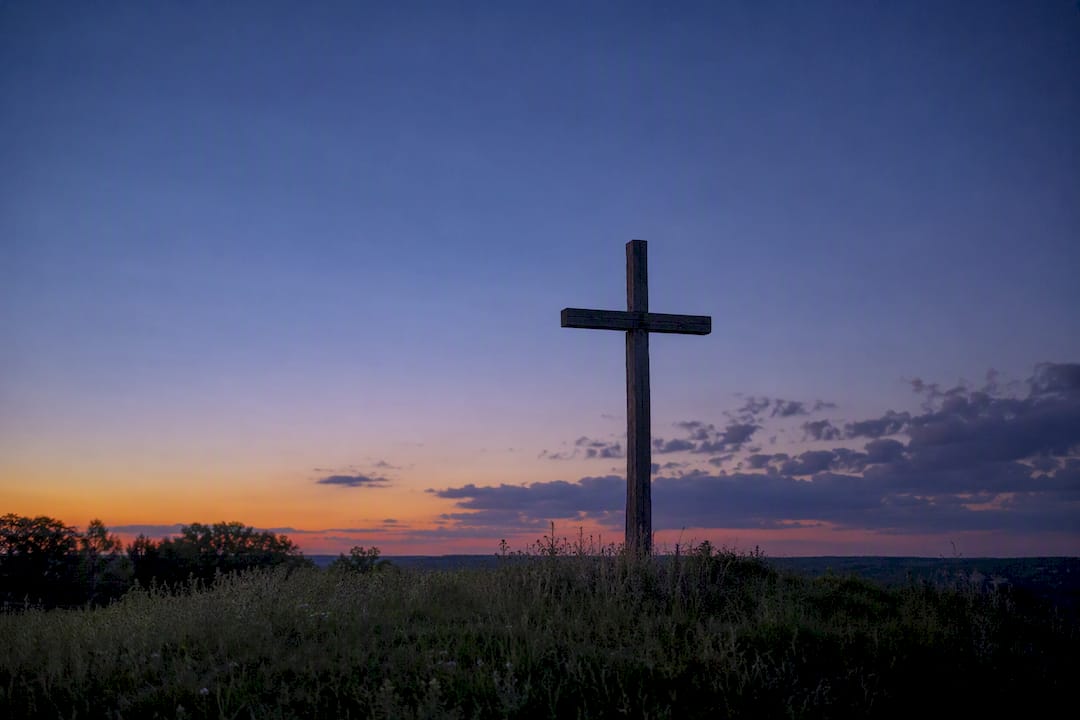 Silhouette of wooden cross at sunset