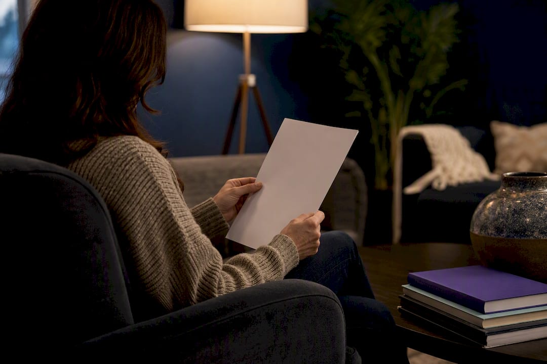 Teacher reviewing contract paper at home desk