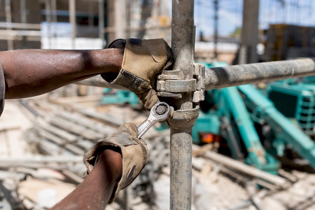Close-up of hands working on scaffold bolt