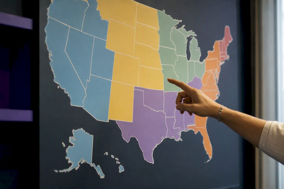 Hand pointing at US map showing geographic pay zones