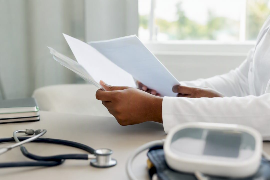 Hands holding immunisation record and fitness certificate
