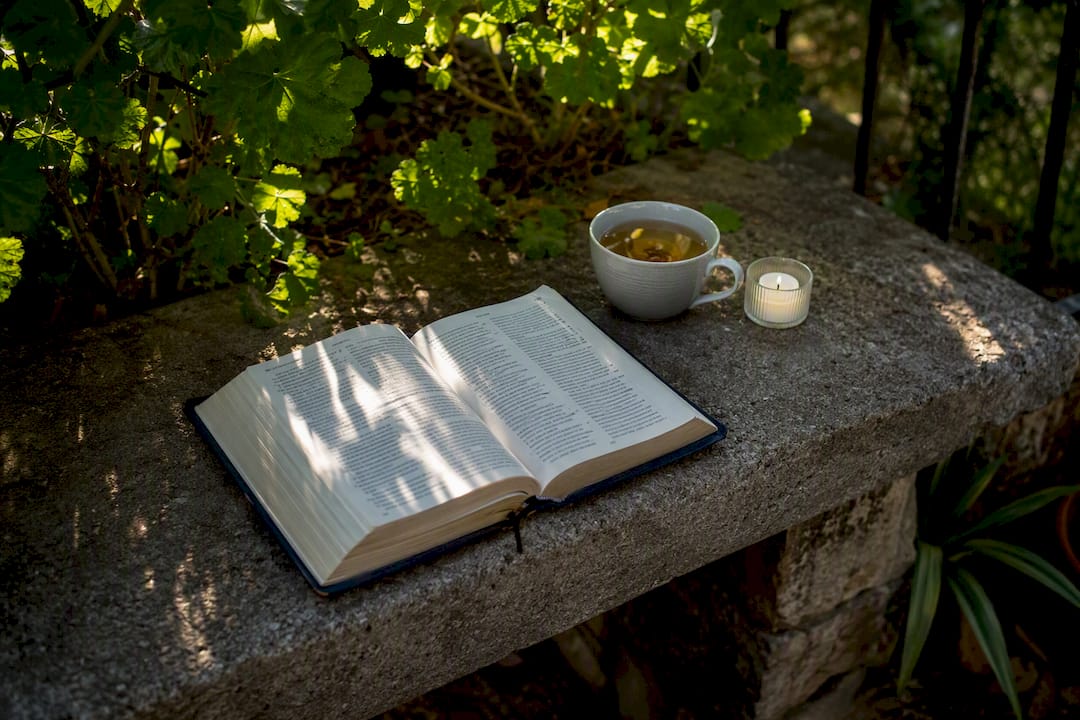 Open Italian Bible with candlelight and glasses