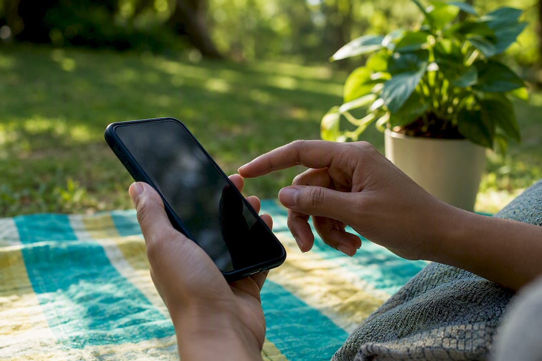 Hands about to use scam check service on phone