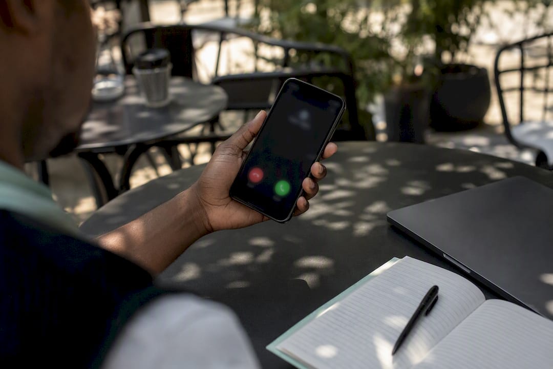 Hand holding phone showing suspicious call