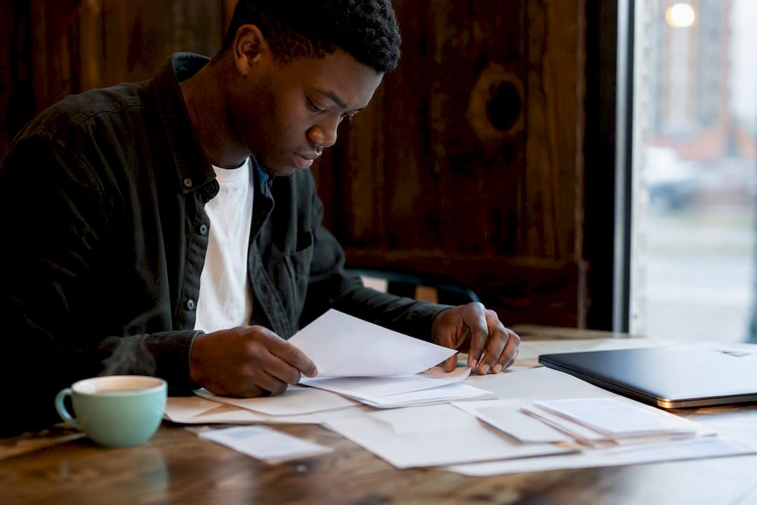 Hands preparing bursary application documents