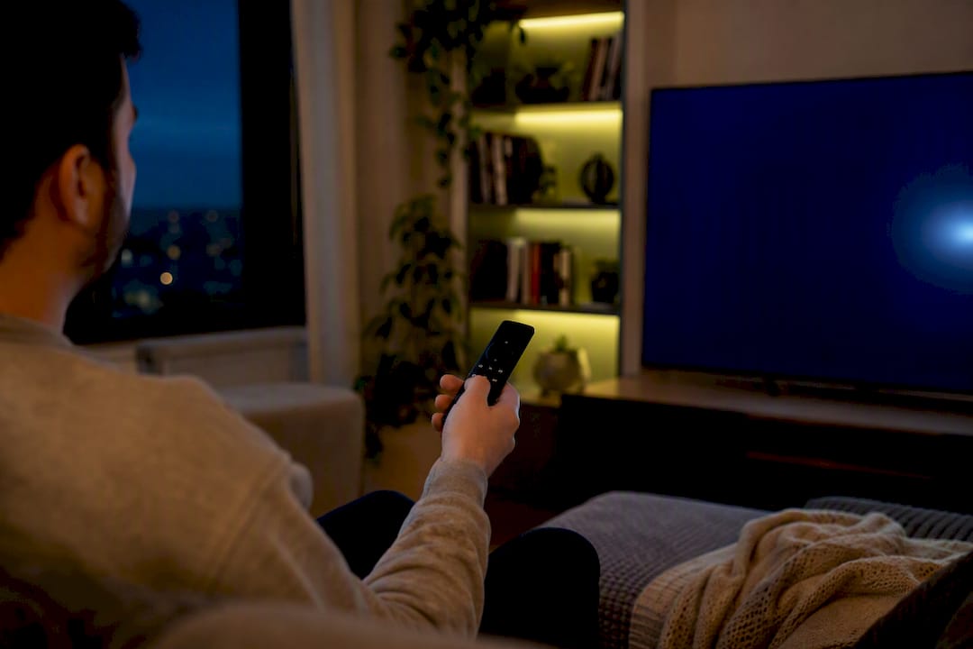 Dłoń naciskająca przycisk pilota Android TV