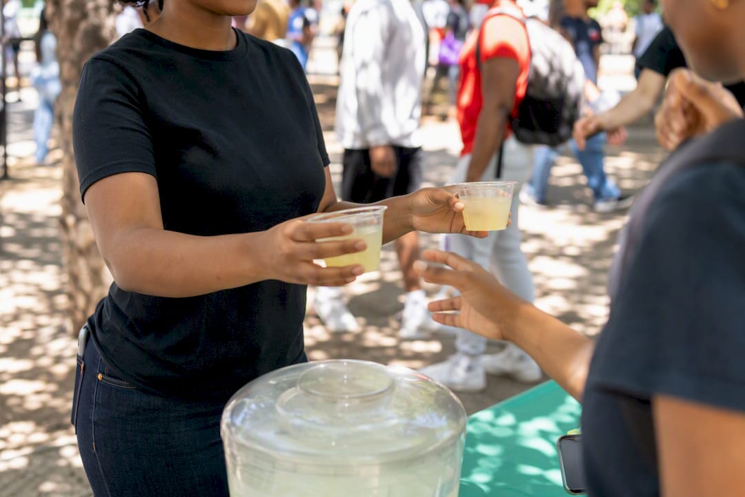 Student handing out drink samples at campus event