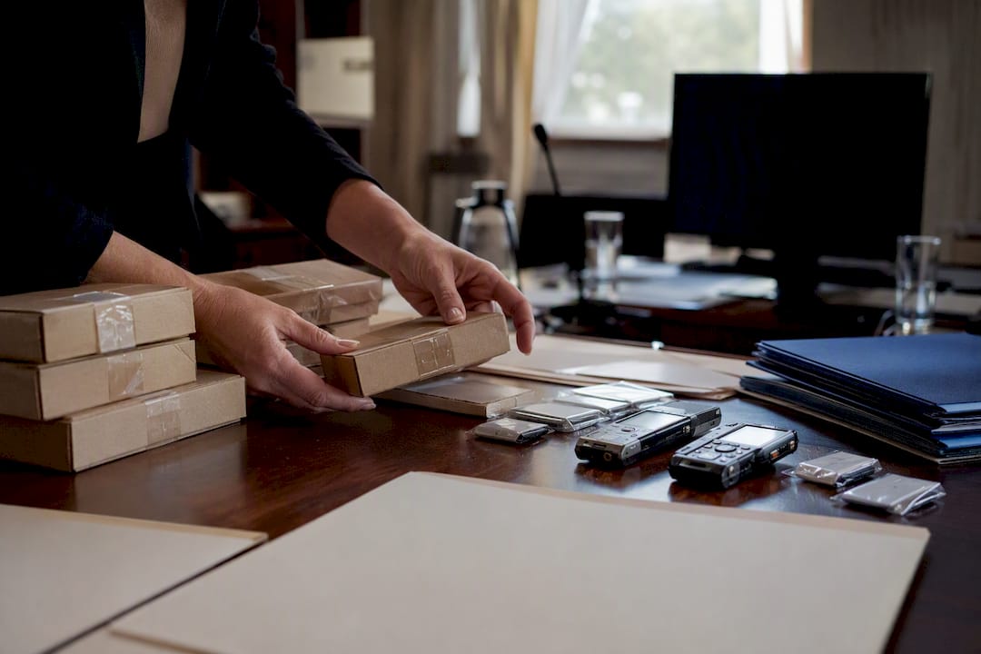 Hands handling evidence boxes in hearing room