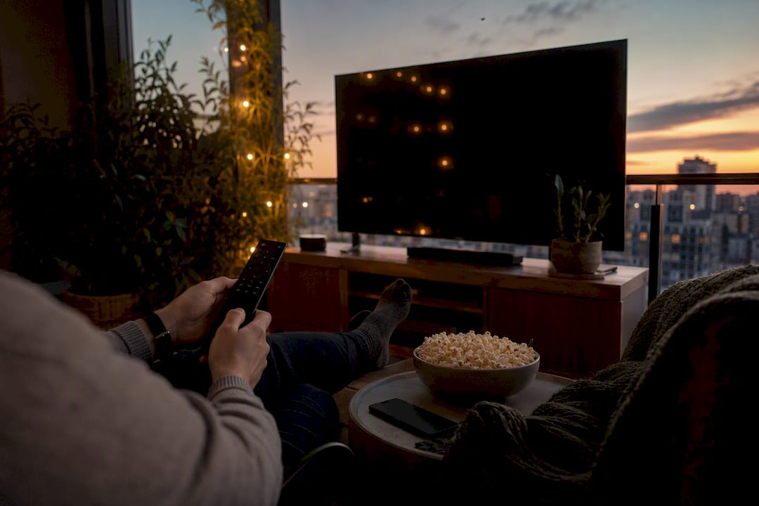 Dłonie trzymające pilot do streamingu anime