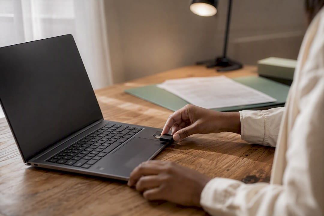 Hands inserting USB drive preparing documents