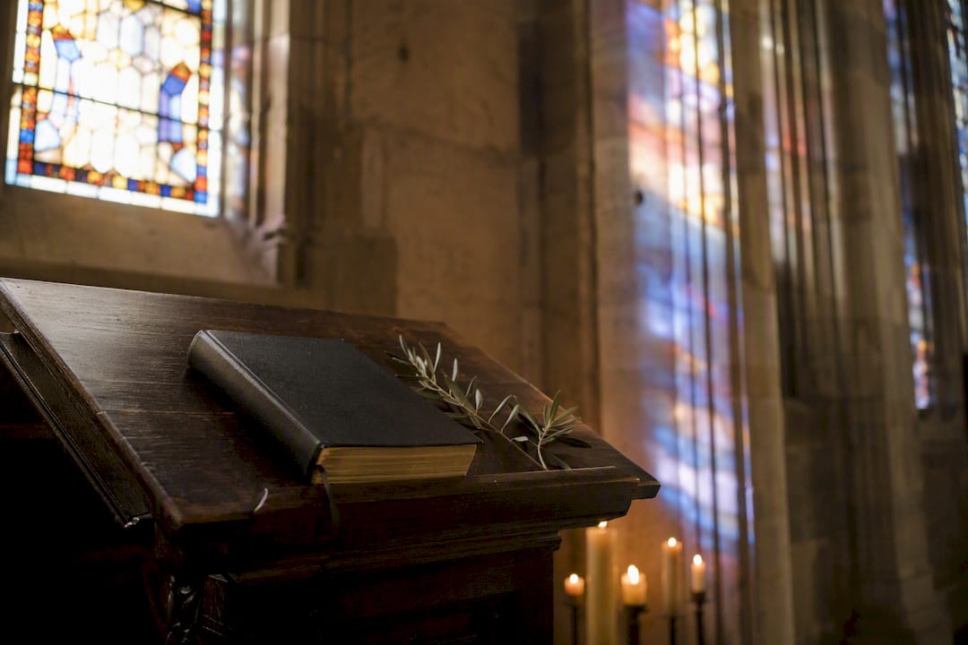 Bibbia e candela sull'angolo dell'altare in chiesa
