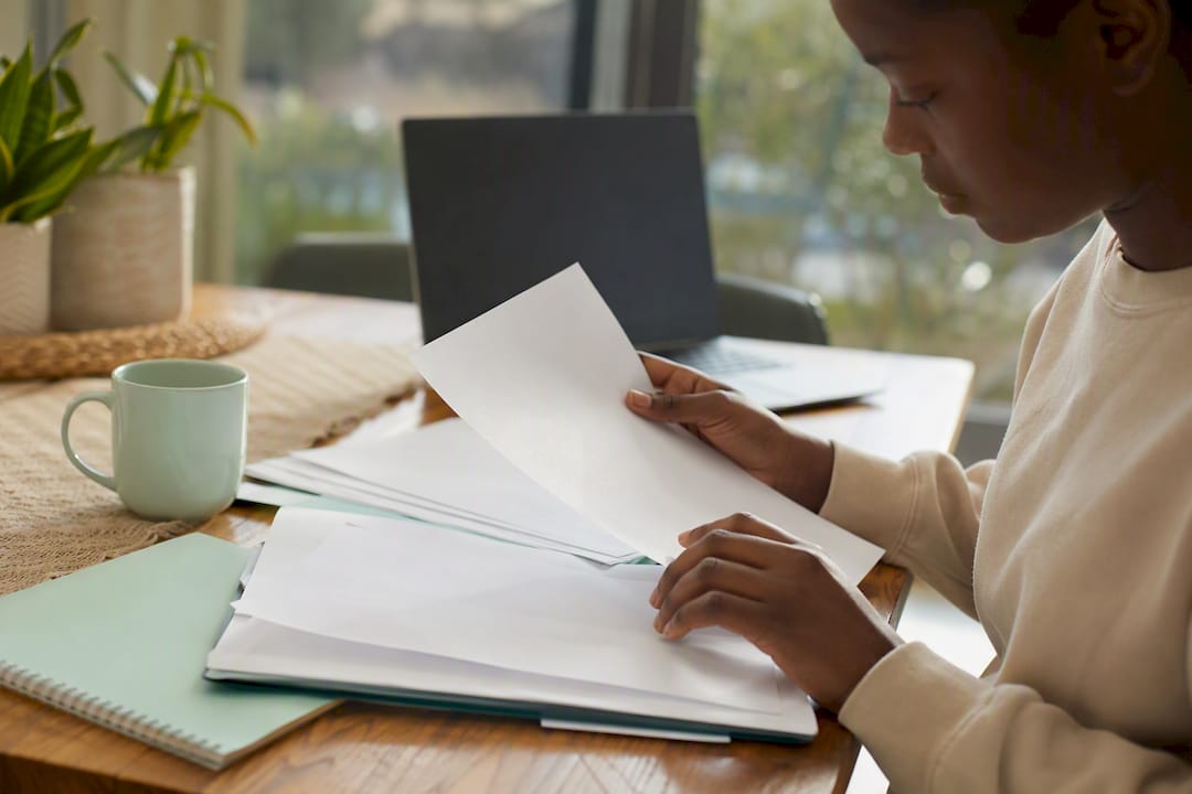 Hands preparing bursary application documents