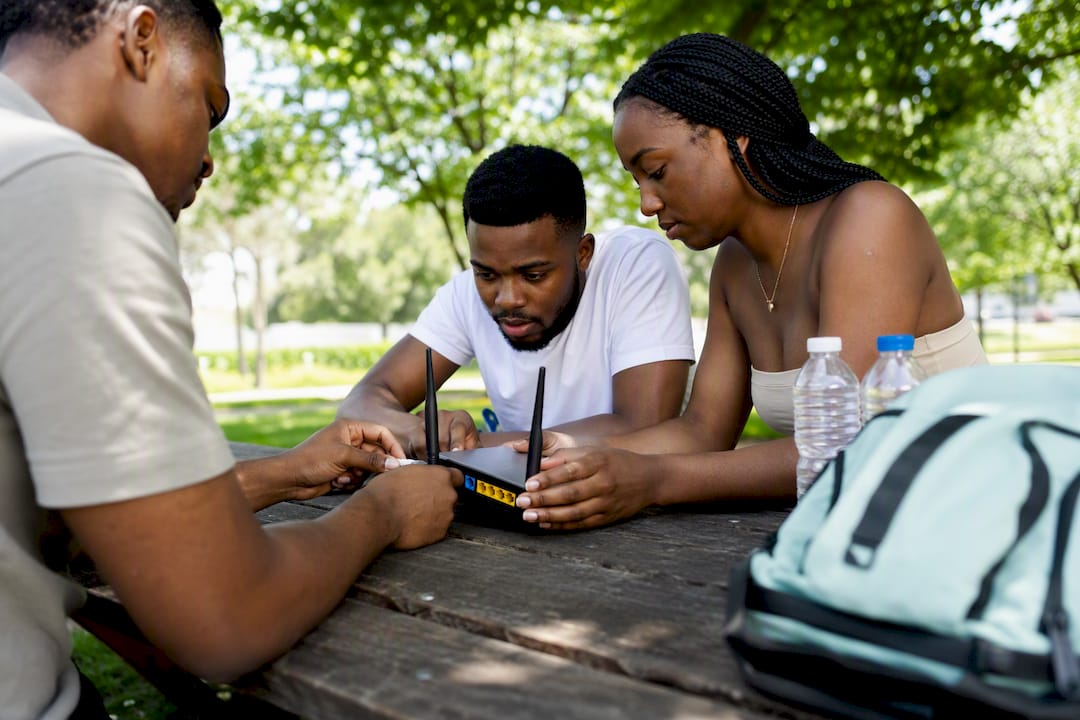 Youth hands connecting networking hardware outdoors
