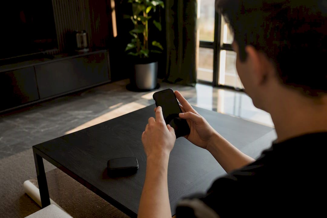 Mani che gestiscono abbonamenti a servizi di streaming su smartphone