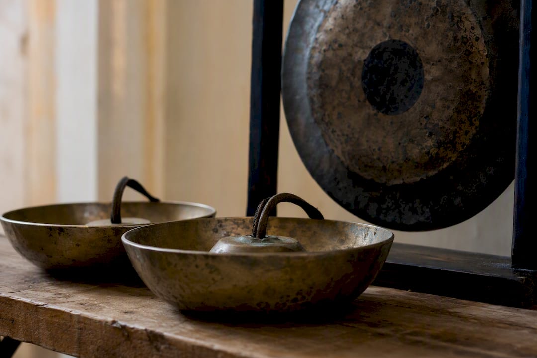 Piatti di bronzo e gong su tavolo di legno
