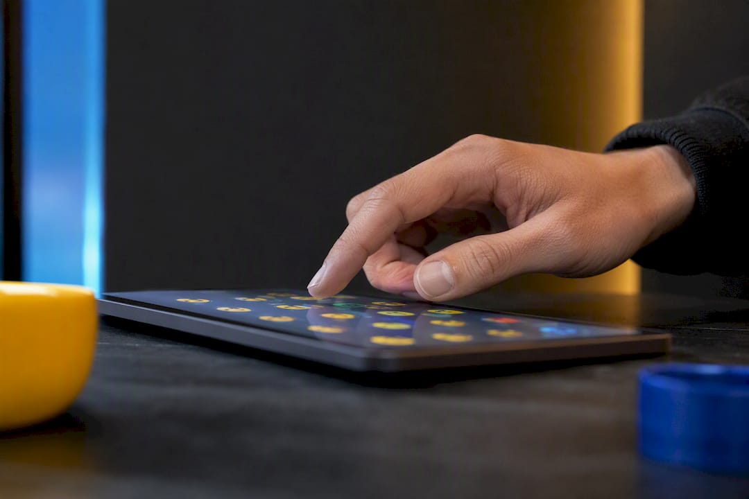 Hand selecting technology emojis on tablet