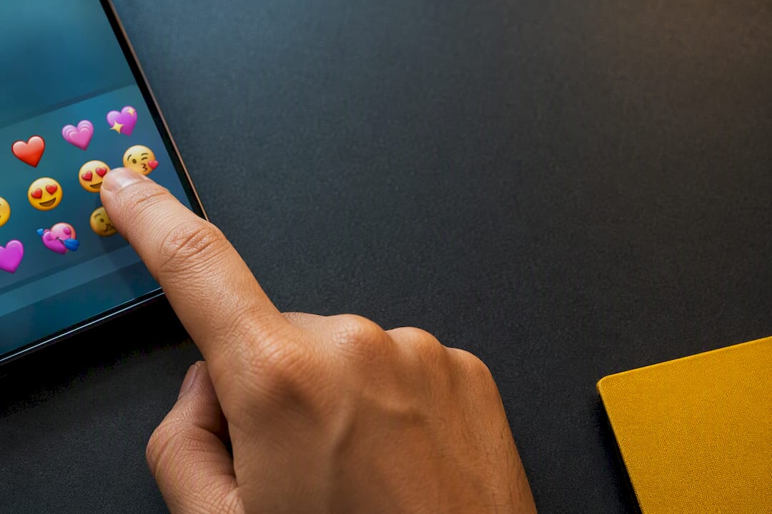 Hand selecting heart and face emojis