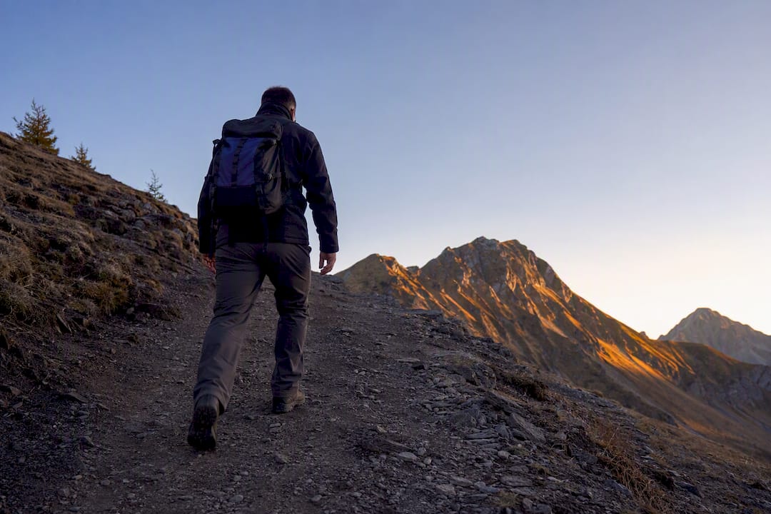 Una persona cammina lungo un sentiero di montagna