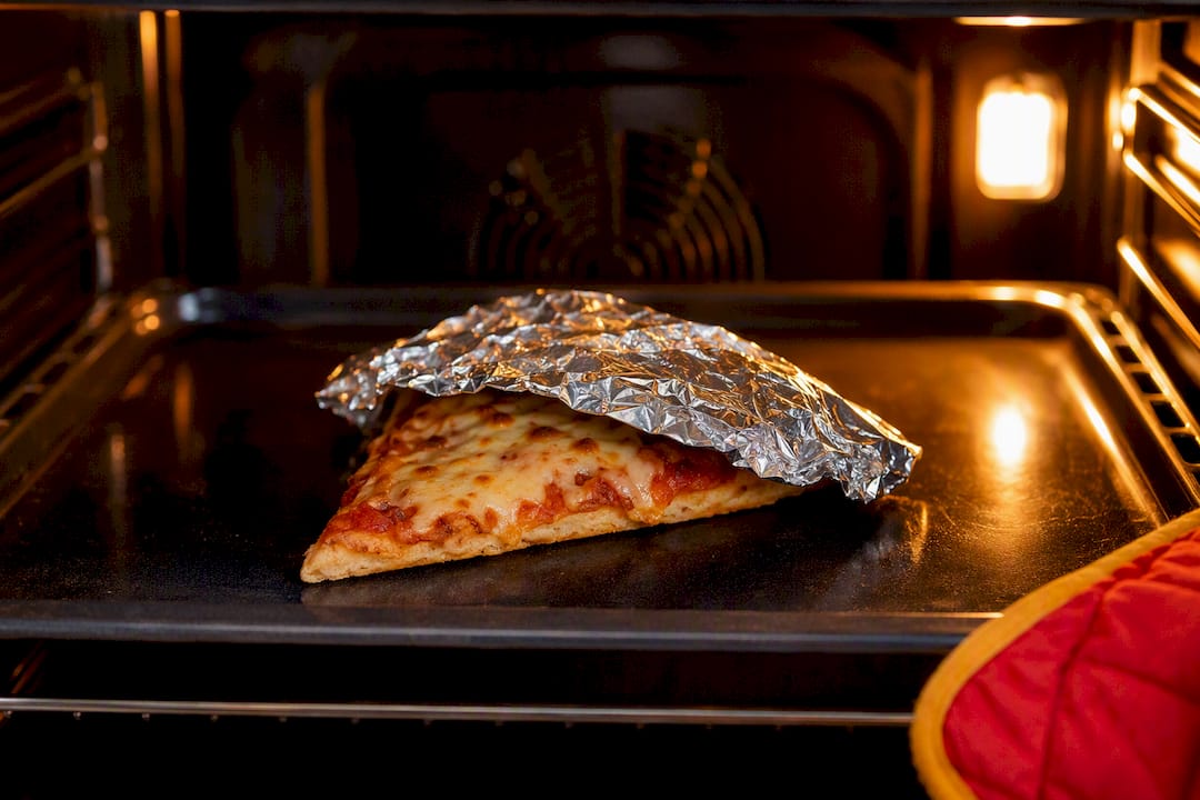 Pizza slice loosely covered with foil