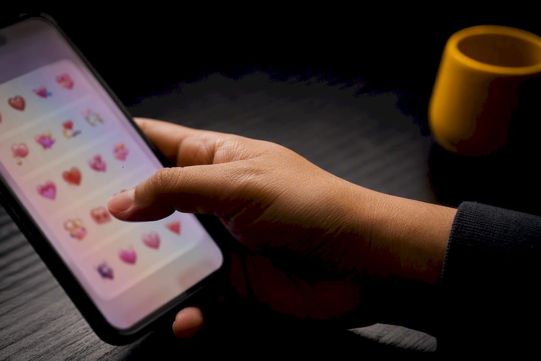 Hand selecting Valentine emoji combinations