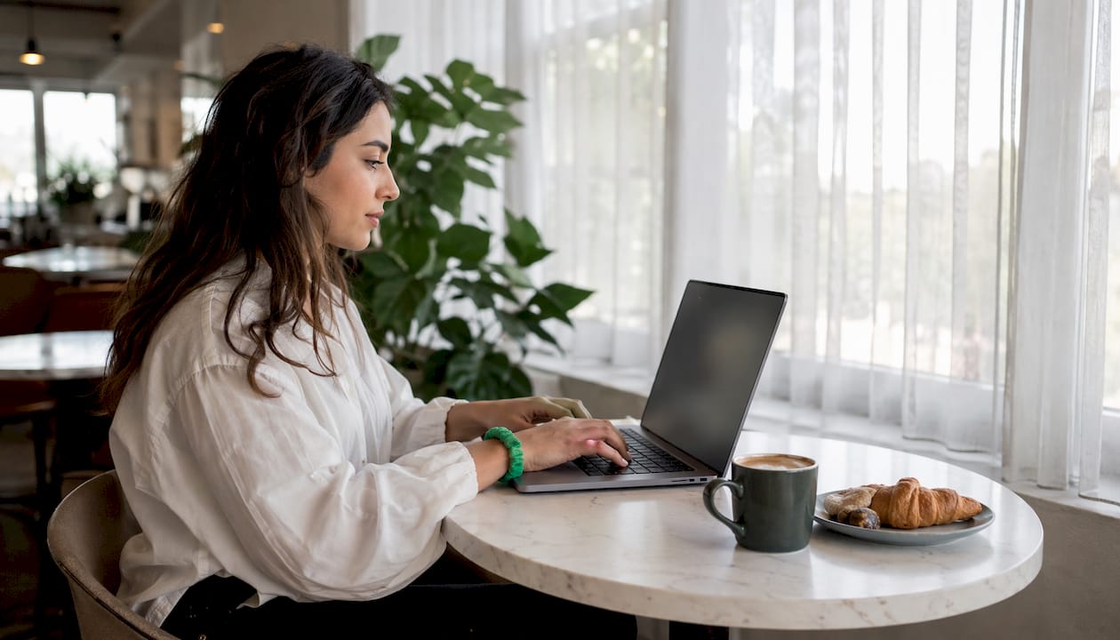 Hands selecting waste type and bin size on laptop keyboard