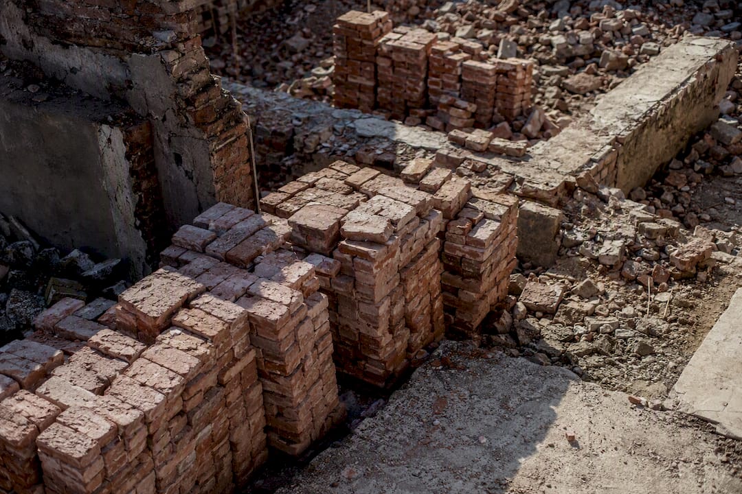 Neatly stacked recycled bricks at demolition site