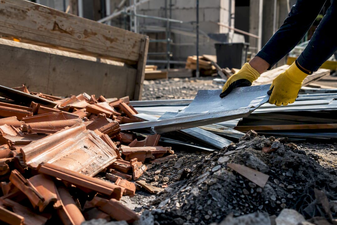 Hands sorting roofing waste piles on site