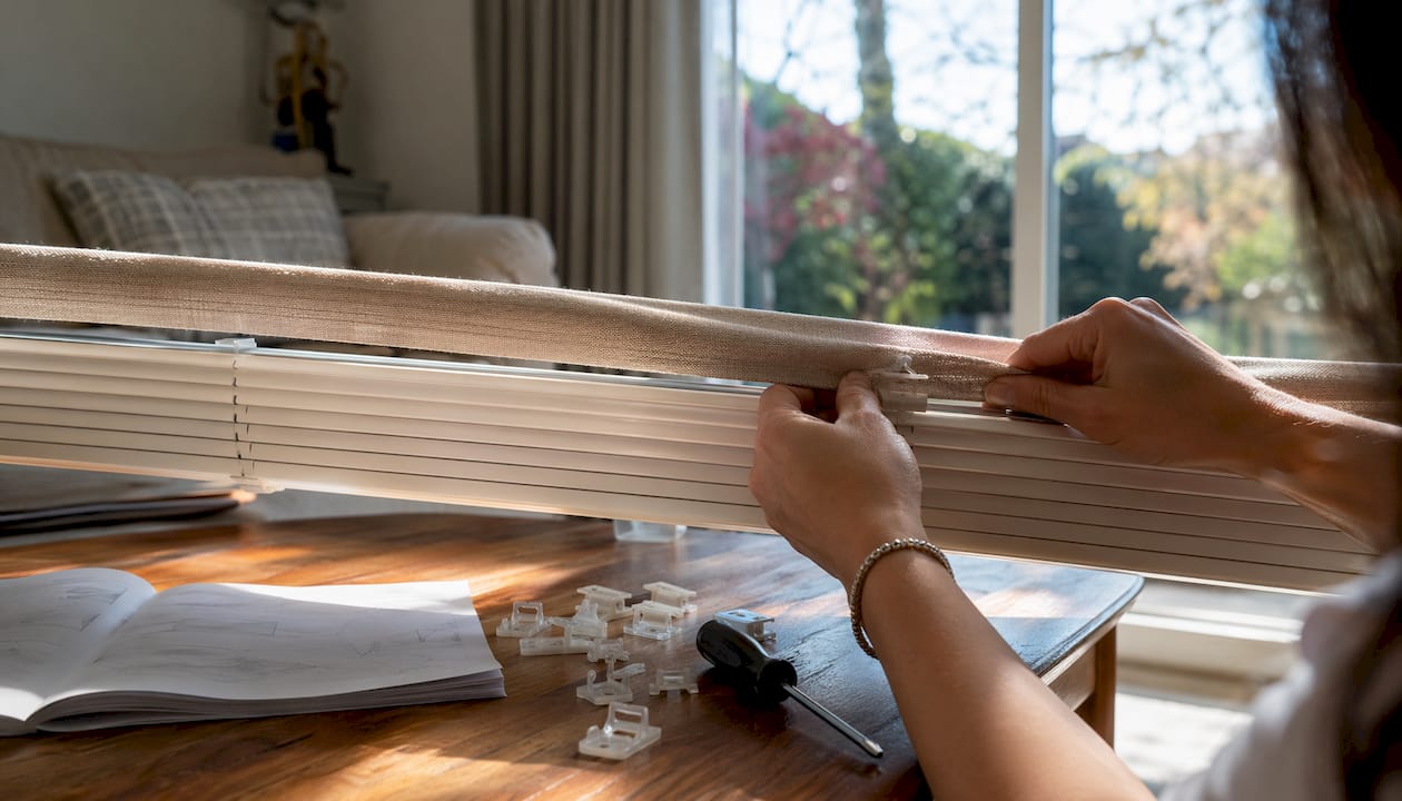 Close-up of hands snapping valance onto blind clips
