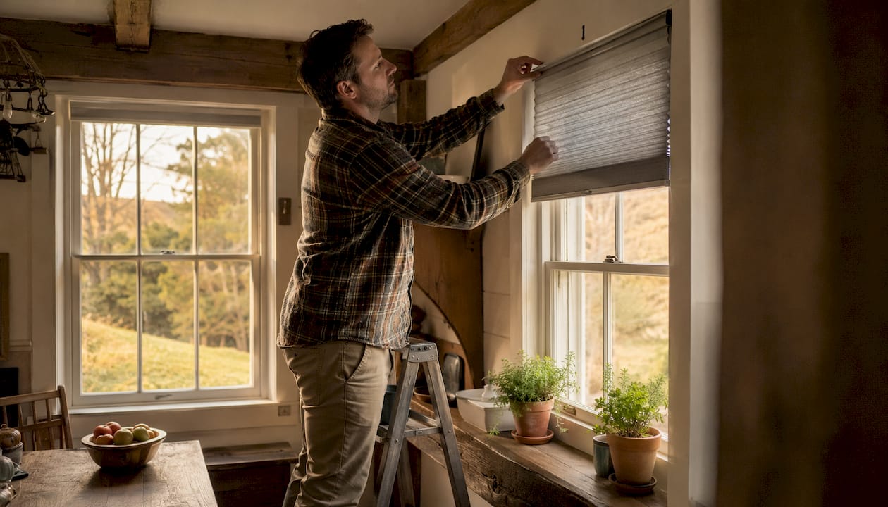 Man installing cellular honeycomb shades