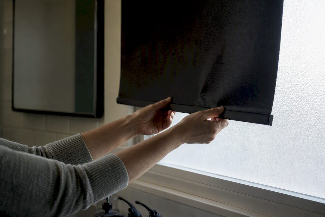 Hands adjusting blackout roller shade