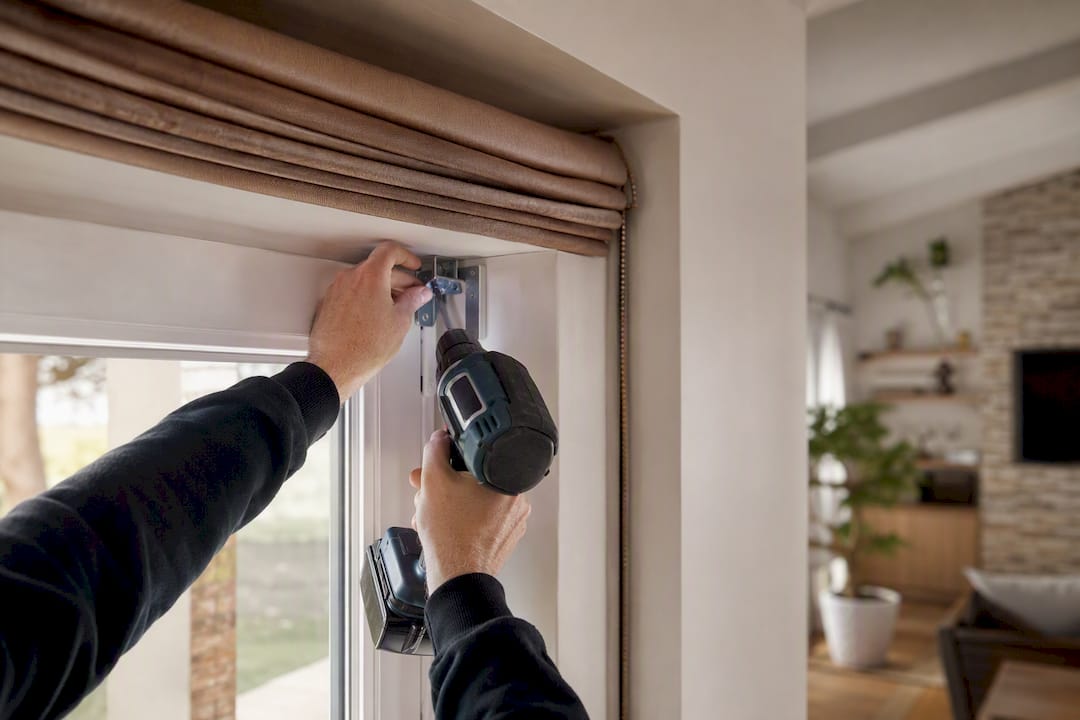 Hands installing motorized roman blind bracket