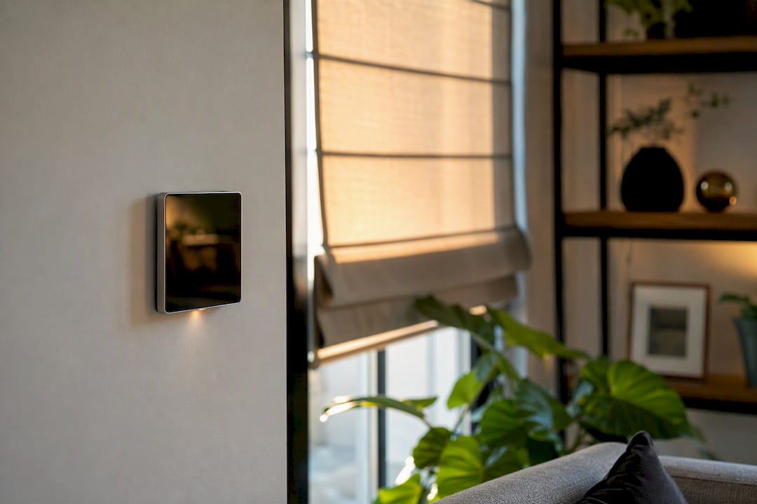 Smart home control panel beside roman blinds window