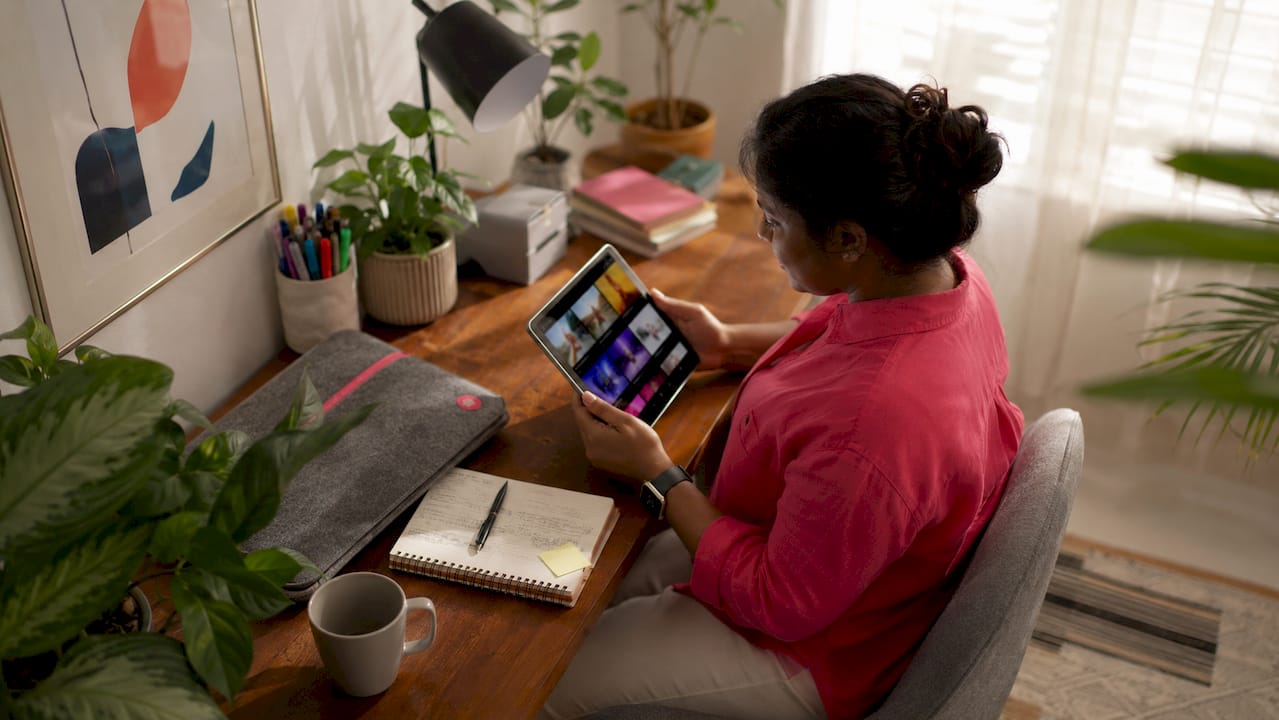 Marketer reviewing static ads on tablet in modern office
