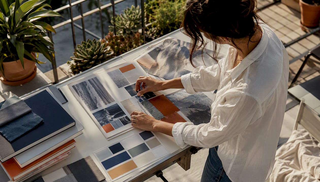 Hands adjusting ad creative mock-ups on light table