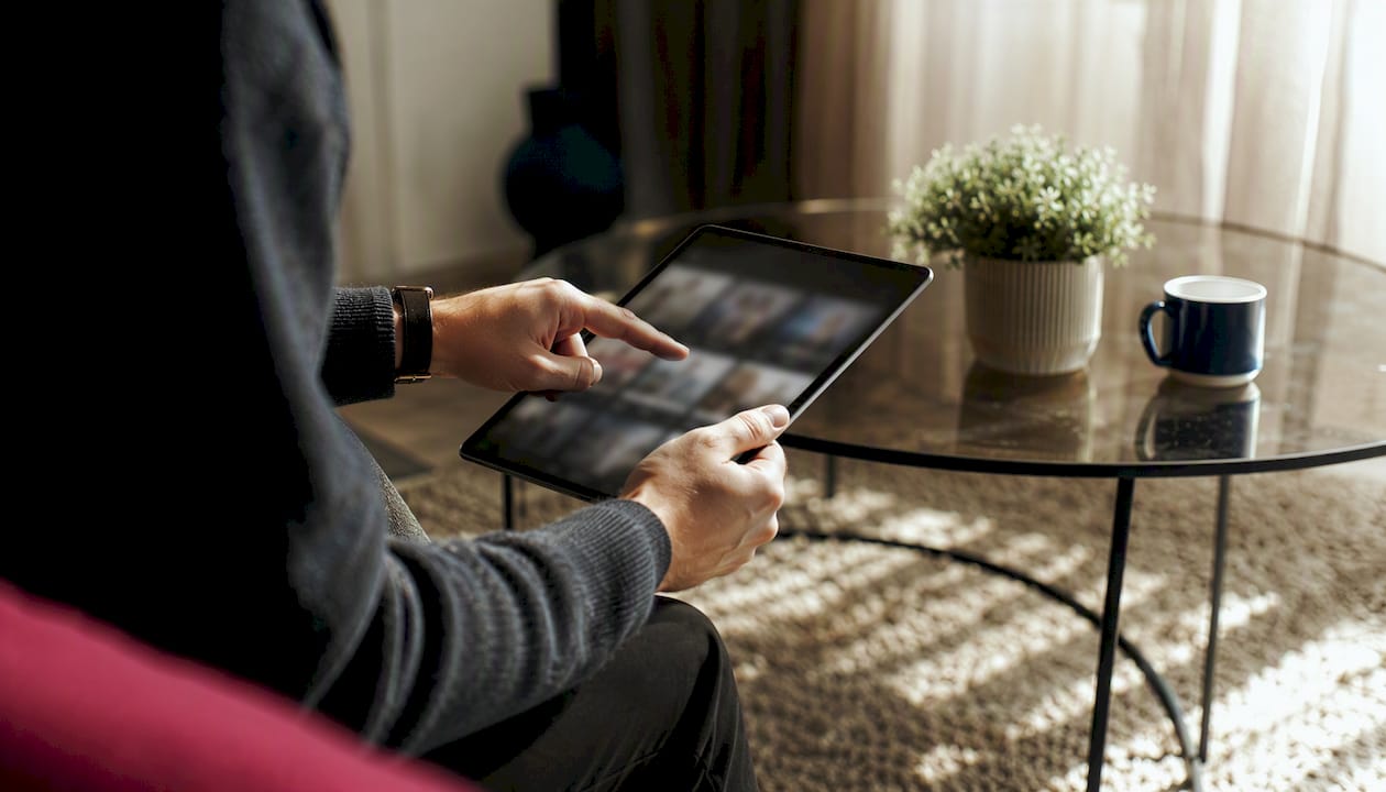 Hand reviewing AI-generated ad variants on tablet