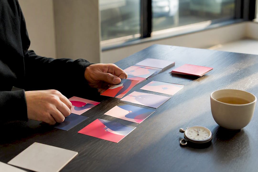 Hands arranging ad concept cards in creative studio
