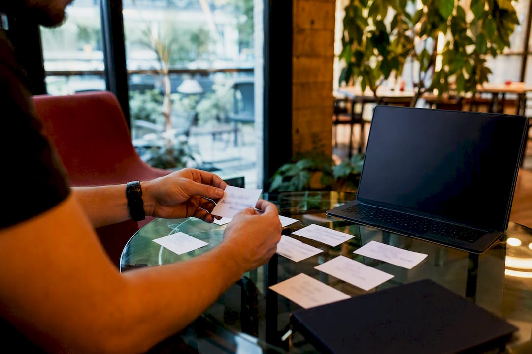 Hands arranging headline cards on table