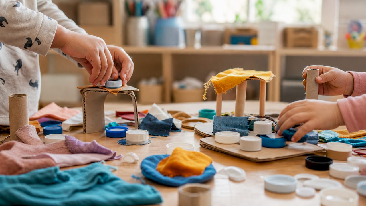 Children's hands playing with upcycled materials