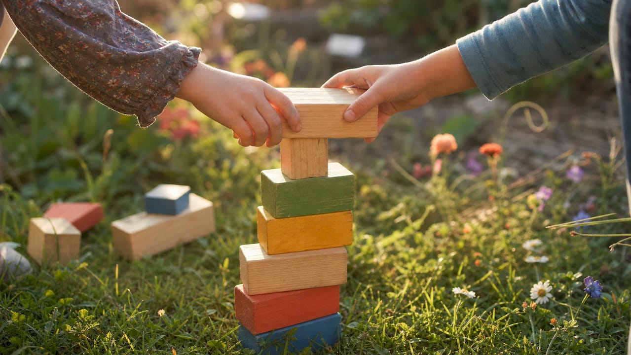 Hands stacking wooden unit blocks