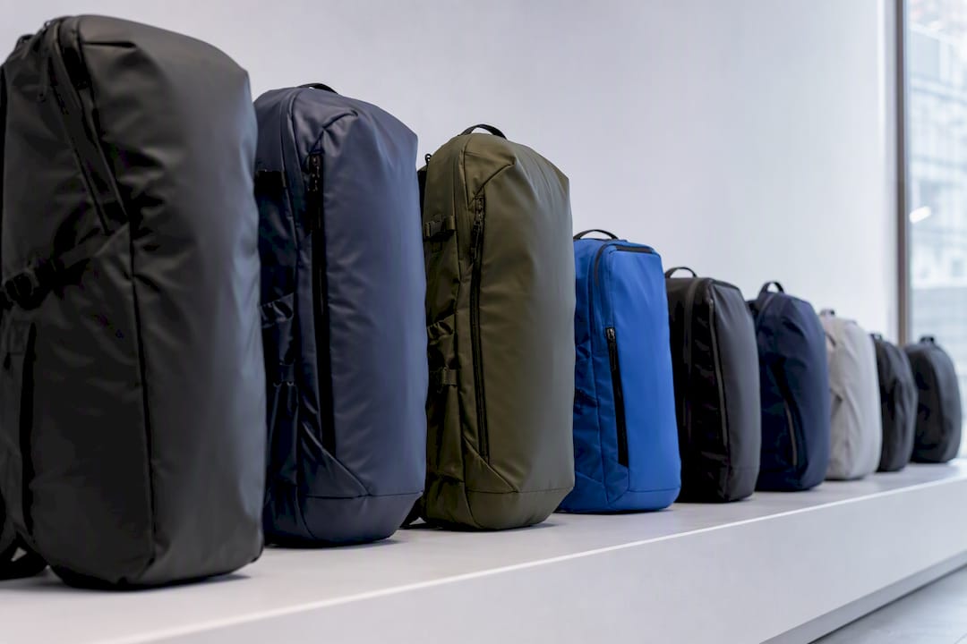 Multiple compact backpacks lined up on shelf