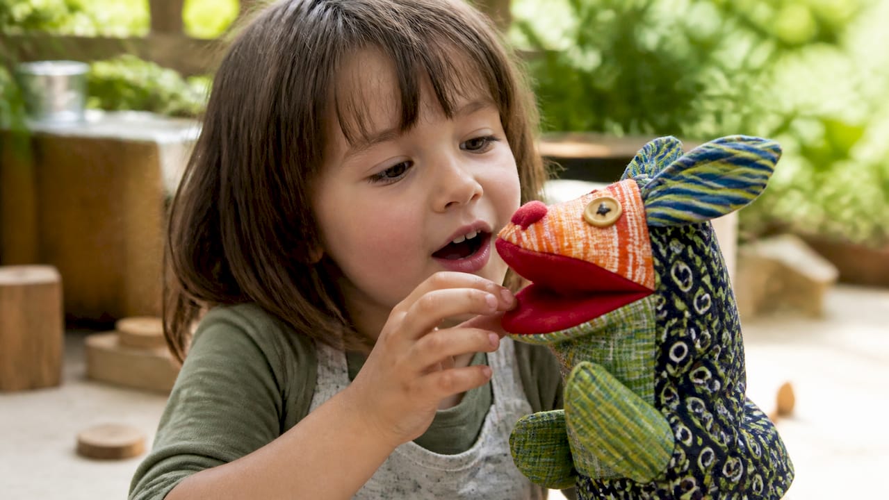 Child's hands talking through puppet