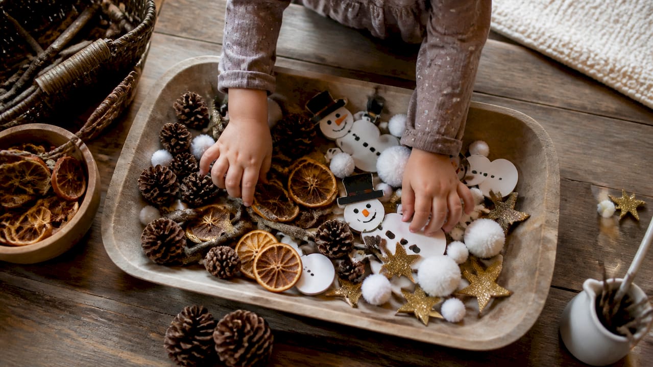 Seasonal holiday materials in tinker tray with hands at work