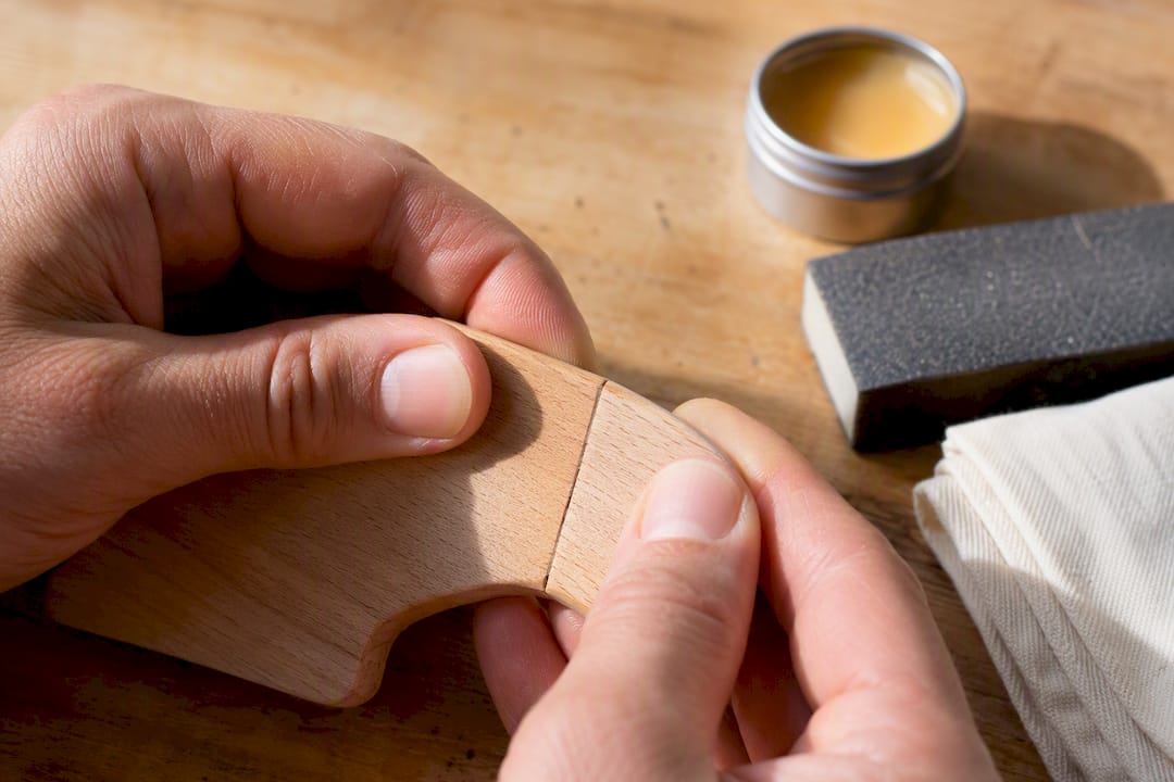 Hands testing a repaired wooden toy joint