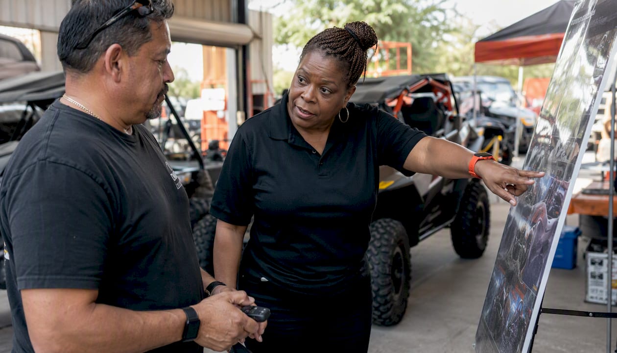 Service advisor consulting UTV buyer indoors