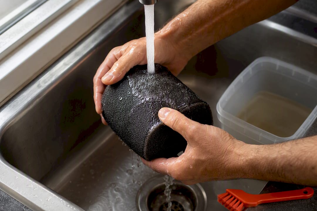 Hands washing a foam ATV air filter
